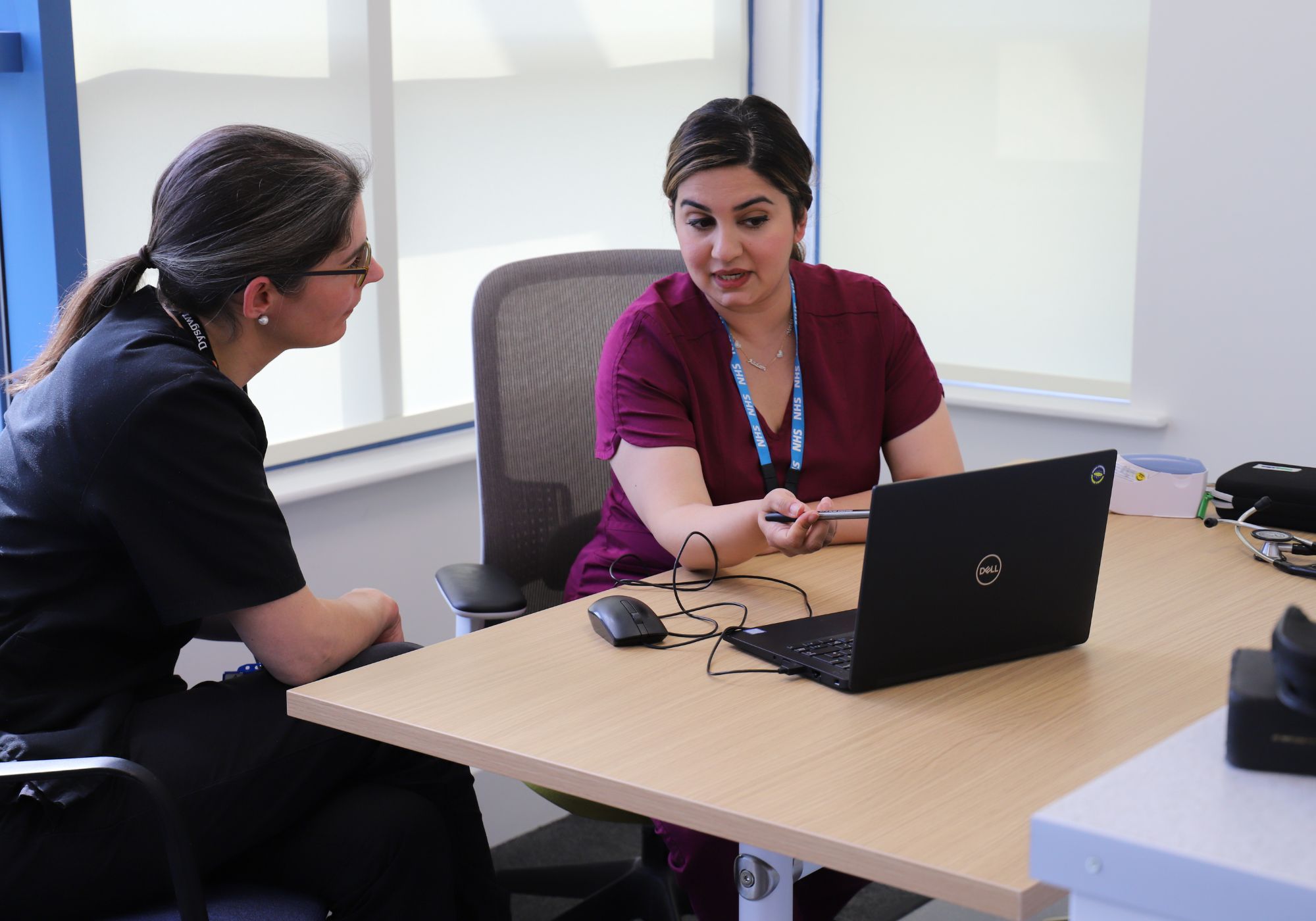 trainee doctor at her desk with a colleague