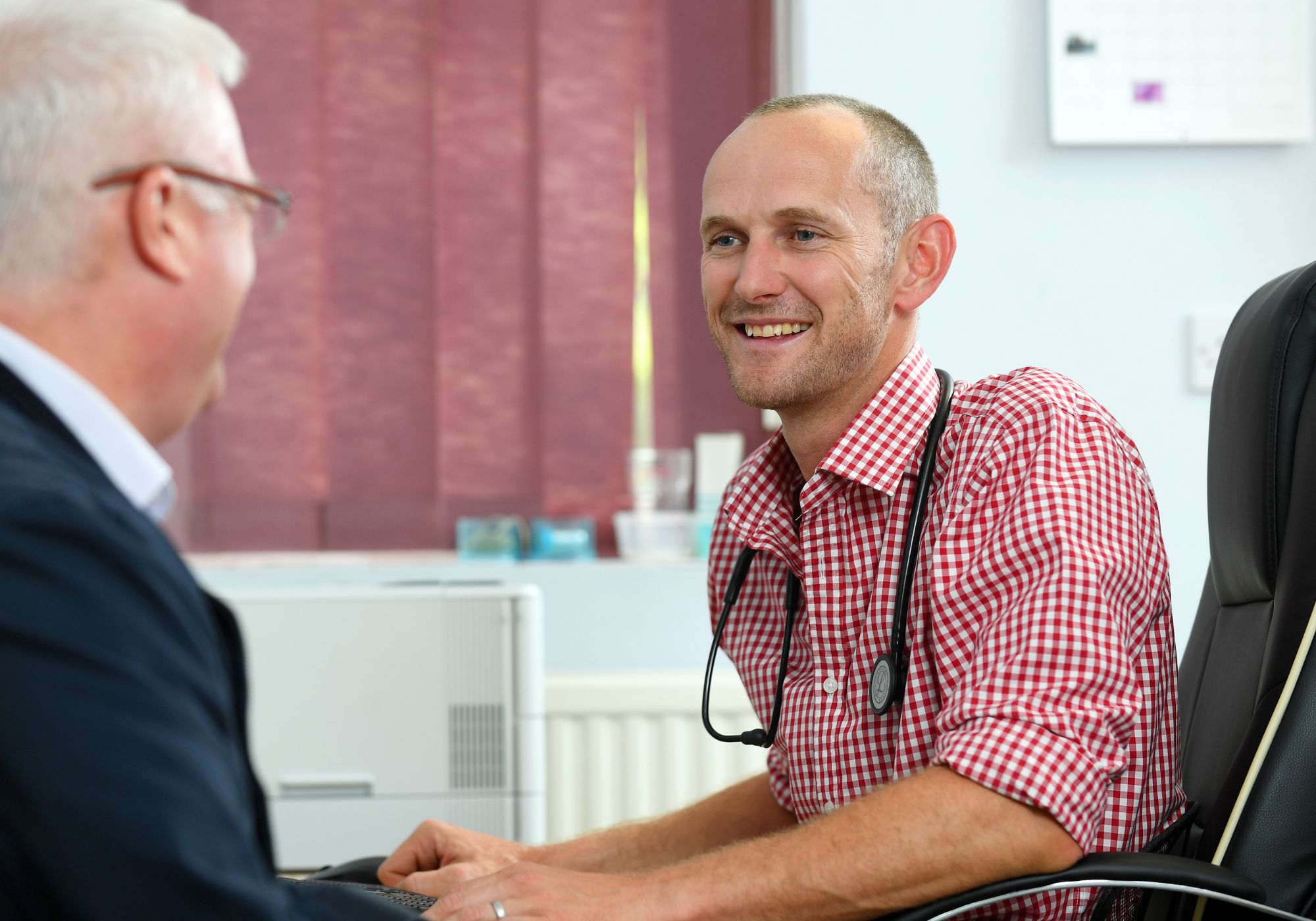 Doctor in a consultation room, speaking with a patient.