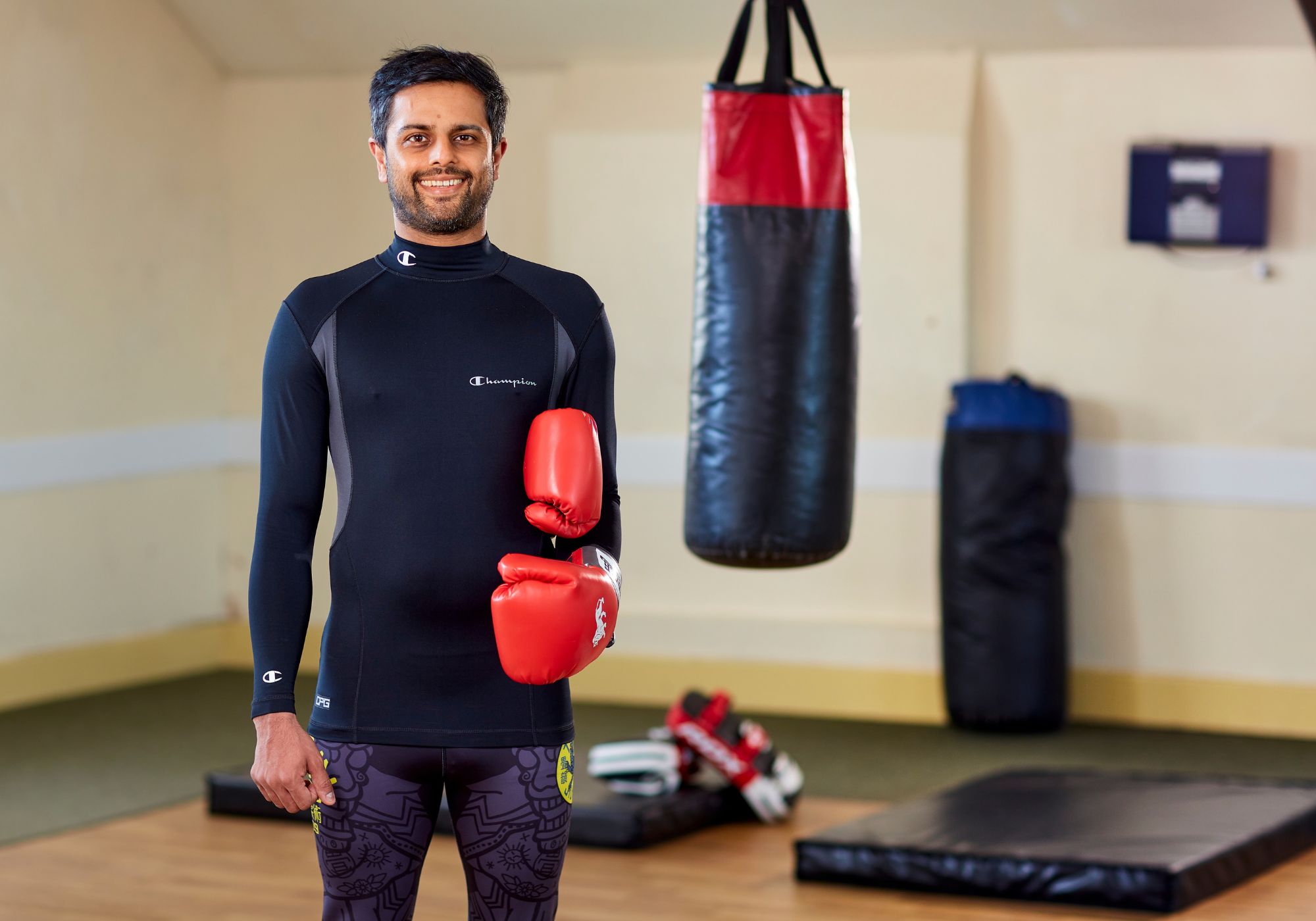 Man at the gym holding boxing gloves